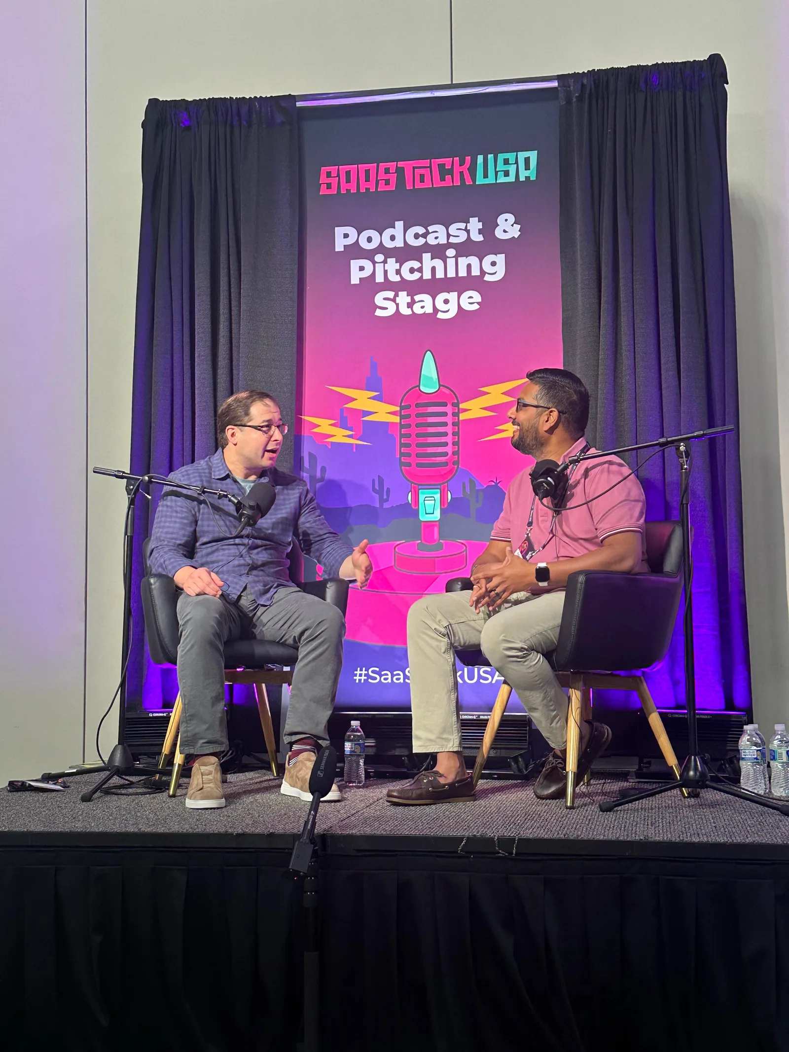 Karthik Puvvada on stage at SaaStock USA in Austin with Jason Cohen
